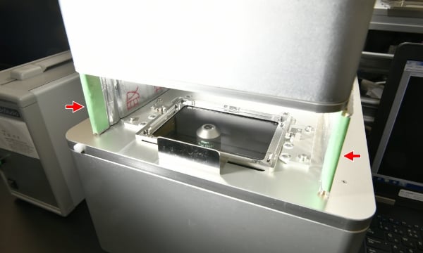 In order to ensure consistent imaging conditions in brighter areas outside the incubator, a light-shielding cover (indicated by arrows) was made and installed.
